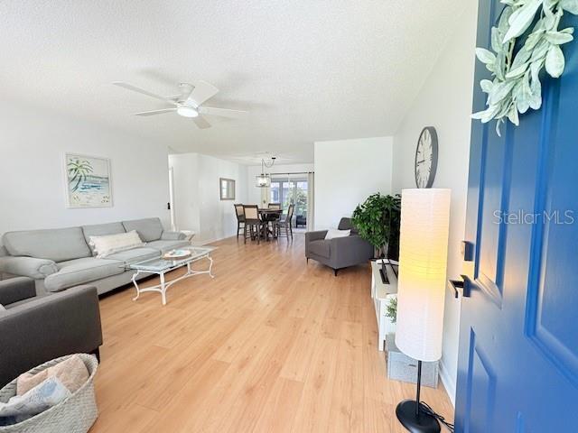 528 Valencia Pl, Lady Lake, FL 32159 - living area with ceiling fan, light wood-type flooring, and a textured ceiling