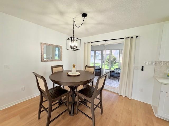 528 Valencia Pl, Lady Lake, FL 32159 - dining room with light wood-type flooring and a chandelier