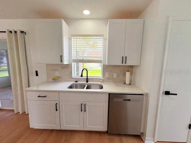 528 Valencia Pl, Lady Lake, FL 32159 - kitchen featuring stainless steel dishwasher, light wood-style floors, and white cabinetry