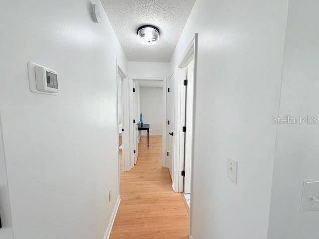 528 Valencia Pl, Lady Lake, FL 32159 - corridor featuring a textured ceiling and light wood-style flooring