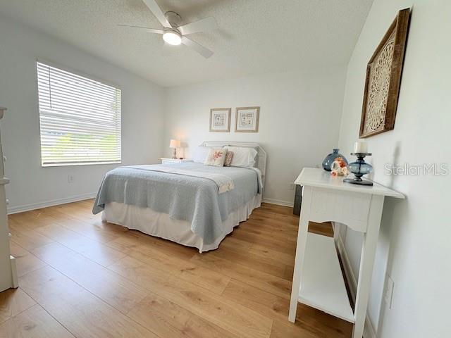 528 Valencia Pl, Lady Lake, FL 32159 - bedroom featuring light wood-style flooring, a textured ceiling, and a ceiling fan