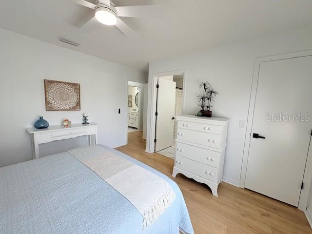 528 Valencia Pl, Lady Lake, FL 32159 - bedroom featuring light wood finished floors, connected bathroom, and ceiling fan