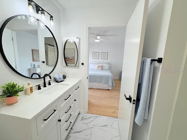 528 Valencia Pl, Lady Lake, FL 32159 - full bath with vanity, marble look tile flooring, and ensuite bath