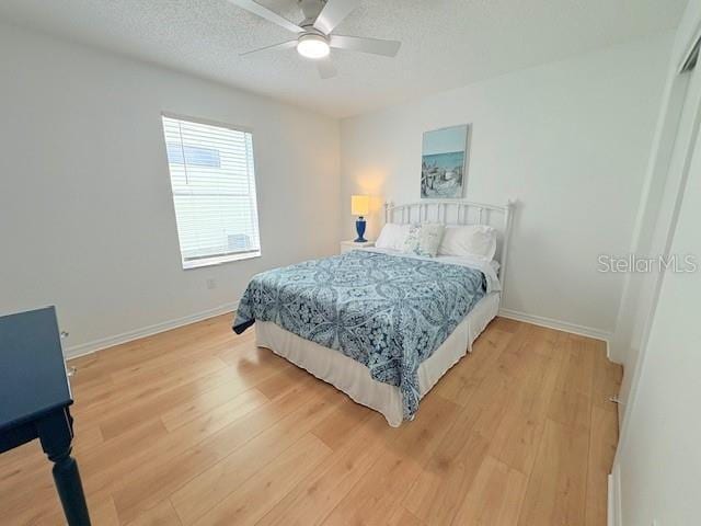 528 Valencia Pl, Lady Lake, FL 32159 - bedroom featuring light wood-style floors, a textured ceiling, and ceiling fan