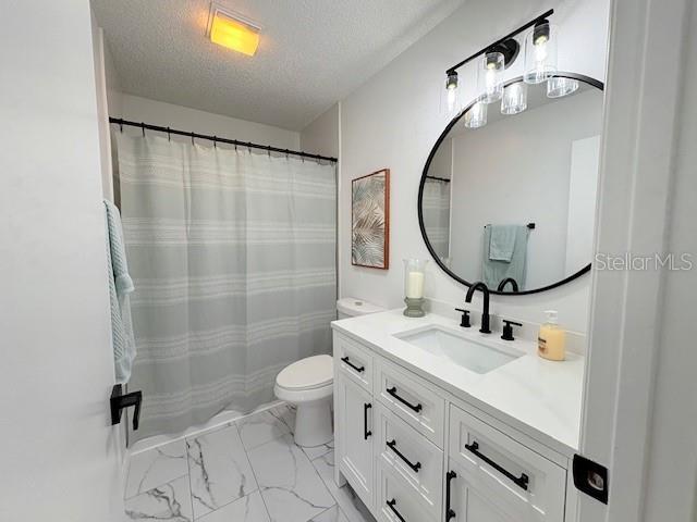 528 Valencia Pl, Lady Lake, FL 32159 - full bath featuring a textured ceiling, vanity, marble look tiles, and curtained shower