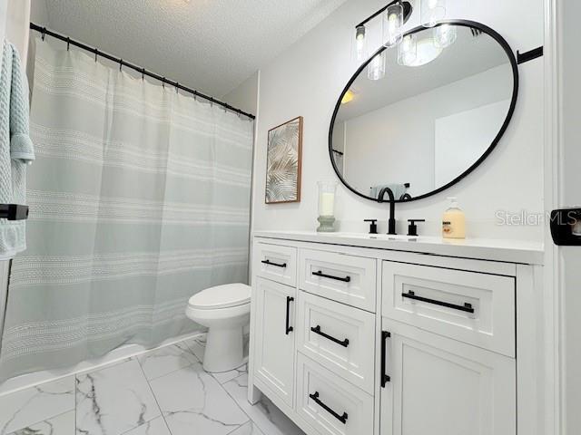 528 Valencia Pl, Lady Lake, FL 32159 - full bath featuring a textured ceiling, vanity, marble look tiles, and a shower with shower curtain
