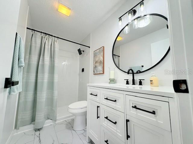 528 Valencia Pl, Lady Lake, FL 32159 - bathroom featuring vanity, marble finish flooring, and curtained shower