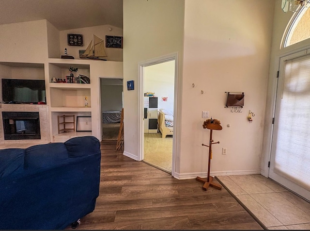 8671 SW 57th Court Rd, Ocala, FL 34476 - living room with wood finished floors, high vaulted ceiling, a multi sided fireplace, and built in features