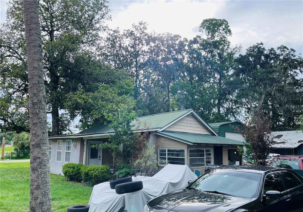 823 NW 24th Pl, Ocala, FL 34475 - view of front of house featuring a metal roof and a front yard
