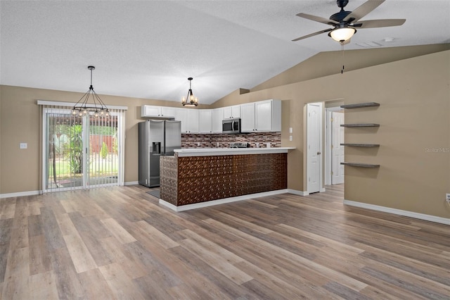 3224 E Davis Ln Unit 29, Inverness, FL 34453 - kitchen with appliances with stainless steel finishes, a chandelier, open floor plan, white cabinets, and lofted ceiling
