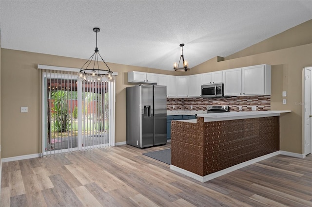3224 E Davis Ln Unit 29, Inverness, FL 34453 - kitchen with stainless steel appliances, a chandelier, light wood-style flooring, a textured ceiling, and vaulted ceiling