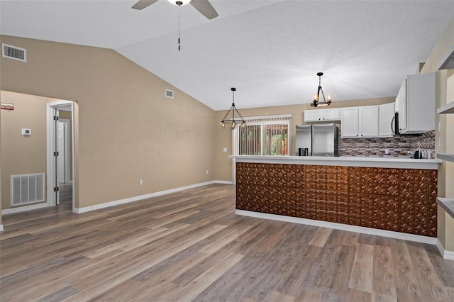 3224 E Davis Ln Unit 29, Inverness, FL 34453 - kitchen featuring stainless steel fridge, lofted ceiling, a chandelier, light wood finished floors, and a peninsula