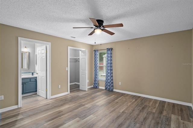 3224 E Davis Ln Unit 29, Inverness, FL 34453 - unfurnished bedroom with wood finished floors, a textured ceiling, connected bathroom, a closet, and a ceiling fan
