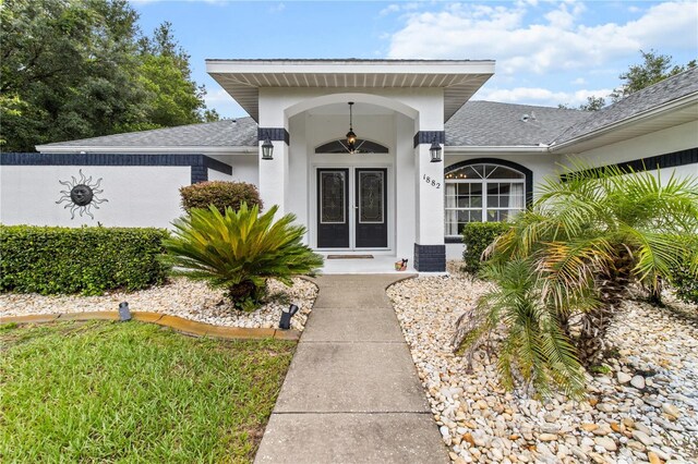 1882 E Monopoly Loop, Inverness, FL 34453 - view of exterior entry featuring roof with shingles and stucco siding