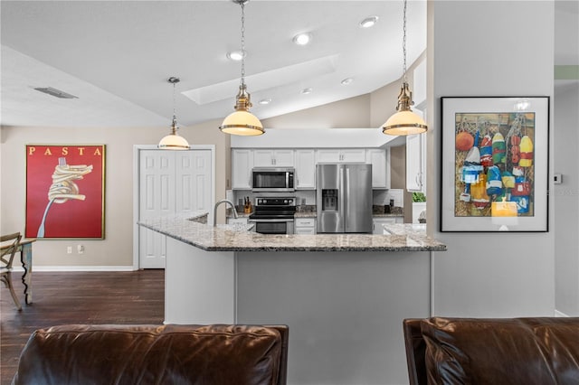 1882 E Monopoly Loop, Inverness, FL 34453 - kitchen with appliances with stainless steel finishes, a skylight, vaulted ceiling, white cabinets, and dark wood finished floors