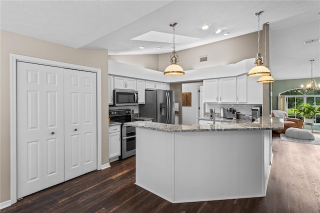 1882 E Monopoly Loop, Inverness, FL 34453 - kitchen featuring stainless steel appliances, light stone countertops, dark wood-style floors, white cabinets, and a peninsula