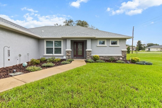 837 E Epsom Ct, Hernando, FL 34442 - view of front facade with stucco siding, a front yard, stone siding, and roof with shingles