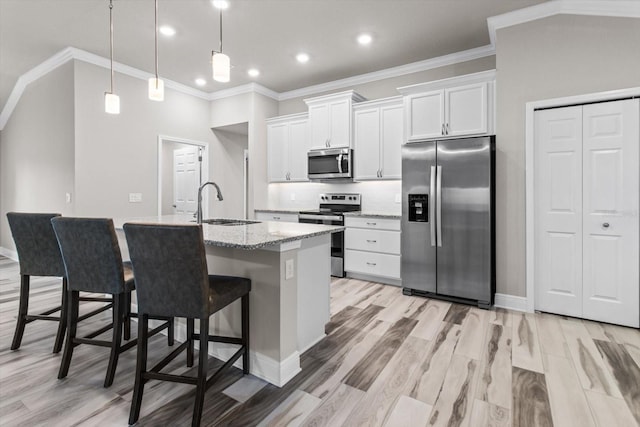 837 E Epsom Ct, Hernando, FL 34442 - kitchen featuring stainless steel appliances, white cabinetry, a kitchen bar, a kitchen island with sink, and light wood-style flooring