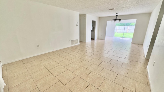 15091 SW 35th Cir, Ocala, FL 34473 - unfurnished room featuring a chandelier, a textured ceiling, and light tile patterned floors