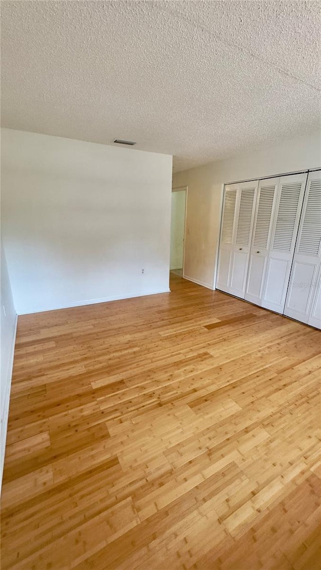 15091 SW 35th Cir, Ocala, FL 34473 - unfurnished bedroom featuring light wood-style flooring, a textured ceiling, and a closet