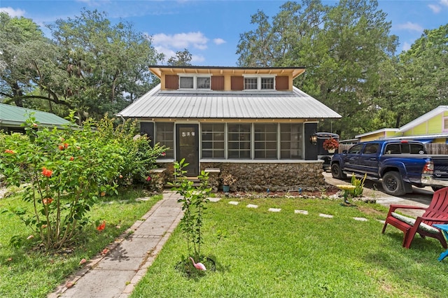 11 62nd St, Yankeetown, FL 34498 - bungalow-style house with stone siding, a sunroom, a front lawn, and a metal roof