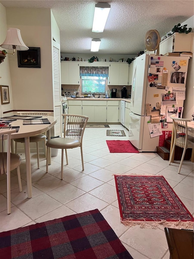 8552 SW 92nd Ln Unit C, Ocala, FL 34481 - kitchen featuring freestanding refrigerator, a textured ceiling, light countertops, and light tile patterned floors