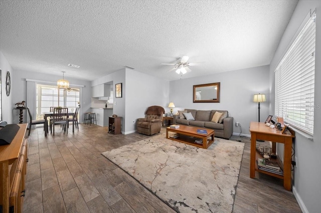 10492 SE 178th St, Summerfield, FL 34491 - living area with dark wood finished floors, a textured ceiling, ceiling fan, and a chandelier