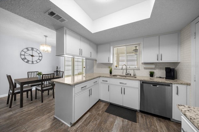 10492 SE 178th St, Summerfield, FL 34491 - kitchen featuring stainless steel dishwasher, dark wood-style floors, a peninsula, backsplash, and a textured ceiling