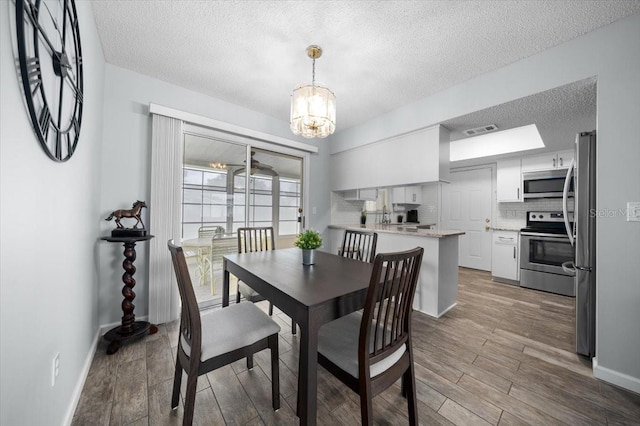 10492 SE 178th St, Summerfield, FL 34491 - dining room with a textured ceiling, a chandelier, and wood finished floors