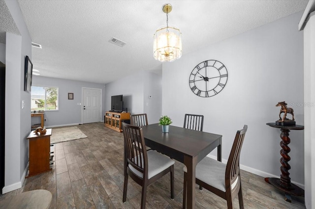 10492 SE 178th St, Summerfield, FL 34491 - dining area featuring a chandelier, a textured ceiling, and dark wood-style flooring