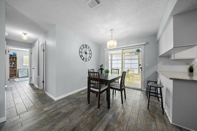 10492 SE 178th St, Summerfield, FL 34491 - dining space with dark wood-style flooring, a chandelier, and a textured ceiling