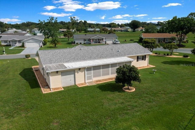 10492 SE 178th St, Summerfield, FL 34491 - rear view of house with a lawn, a garage, a residential view, and a sunroom