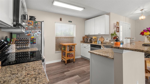 705 Guava Dr, Saint Augustine, FL 32095 - kitchen with a peninsula, wood finished floors, light stone counters, white cabinets, and appliances with stainless steel finishes