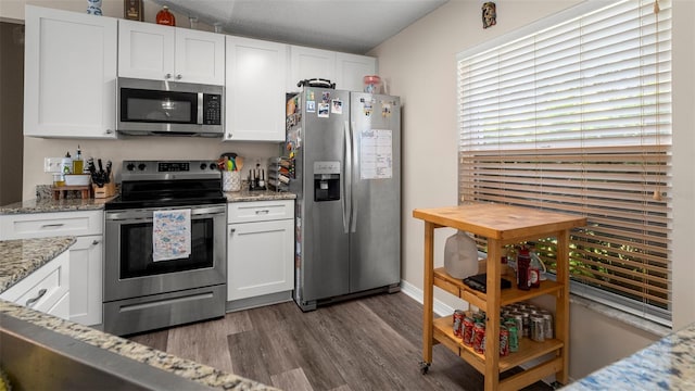 705 Guava Dr, Saint Augustine, FL 32095 - kitchen featuring appliances with stainless steel finishes, dark wood-type flooring, and white cabinets