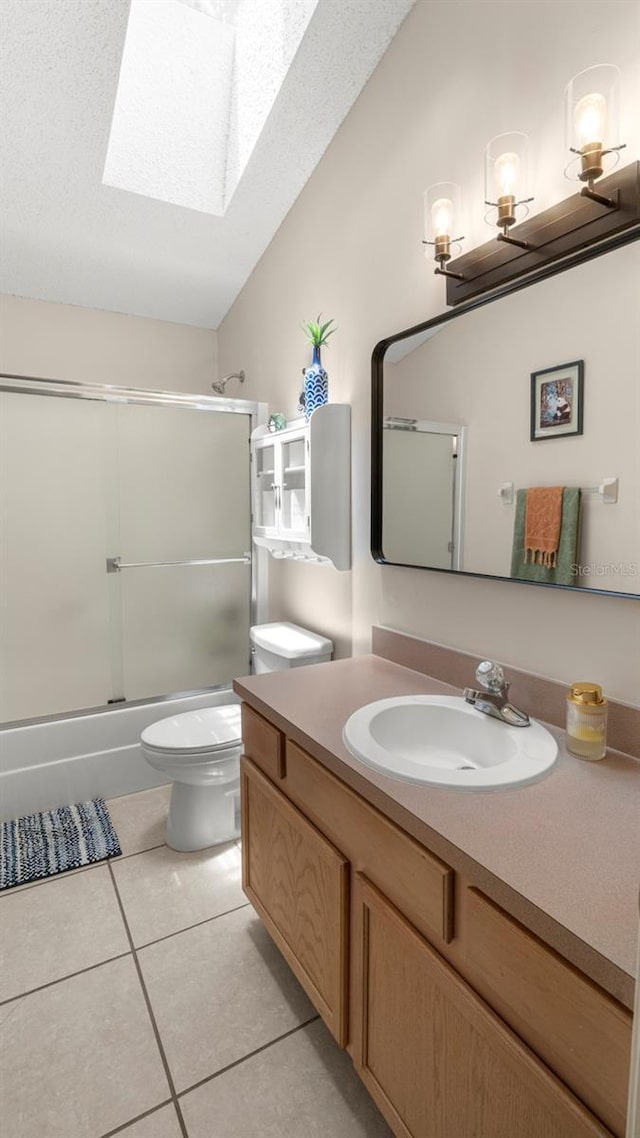 705 Guava Dr, Saint Augustine, FL 32095 - bathroom with a skylight, vanity, tile patterned flooring, and shower / bath combination with glass door