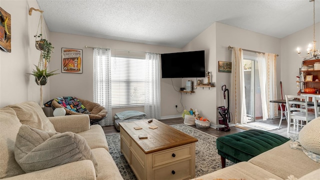 705 Guava Dr, Saint Augustine, FL 32095 - living room with a chandelier, wood finished floors, a textured ceiling, and lofted ceiling