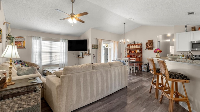 705 Guava Dr, Saint Augustine, FL 32095 - living area featuring vaulted ceiling, a chandelier, dark wood-style flooring, ceiling fan, and a textured ceiling
