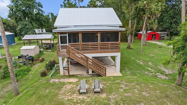 5328 Riverside Dr, Yankeetown, FL 34498 - rear view of house with a sunroom, a yard, an outbuilding, and stairway