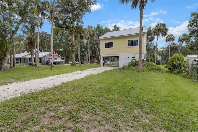 5328 Riverside Dr, Yankeetown, FL 34498 - rear view of property with a carport, dirt driveway, a yard, and a metal roof