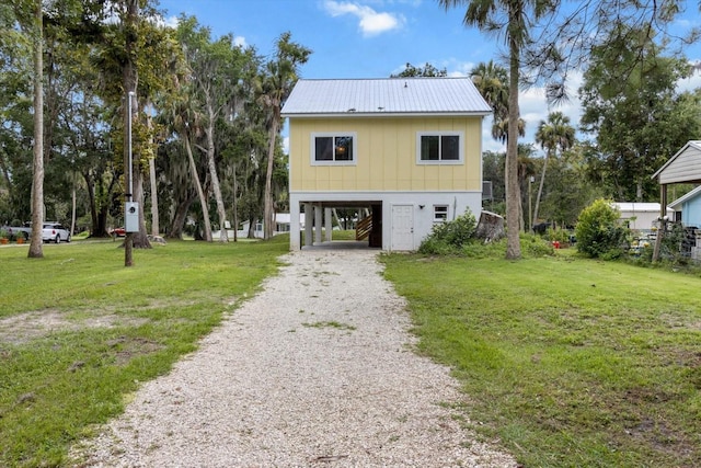 5328 Riverside Dr, Yankeetown, FL 34498 - view of front of home featuring a carport, gravel driveway, a front yard, and a metal roof