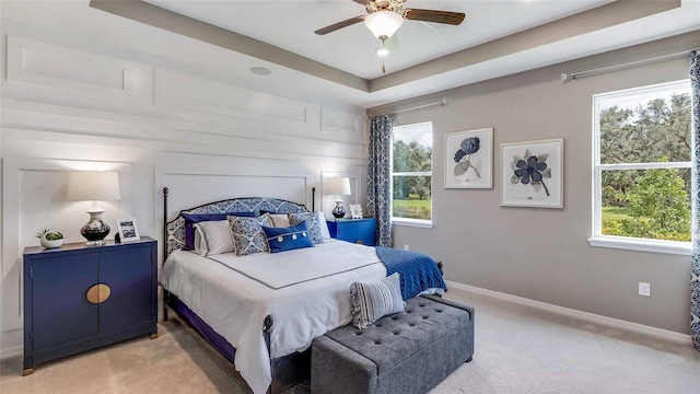 4253 SW 54th Street Rd, Ocala, FL 34474 - bedroom featuring light colored carpet, multiple windows, a ceiling fan, and a tray ceiling