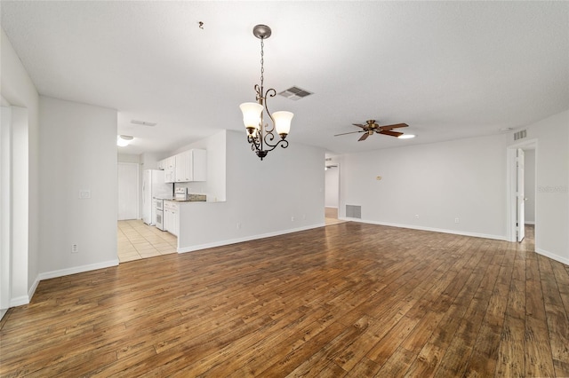 9117 SW 93rd Cir, Ocala, FL 34481 - unfurnished living room featuring a ceiling fan, light wood-style flooring, and a chandelier