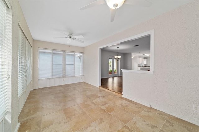 9117 SW 93rd Cir, Ocala, FL 34481 - unfurnished room with ceiling fan, a chandelier, and a textured wall