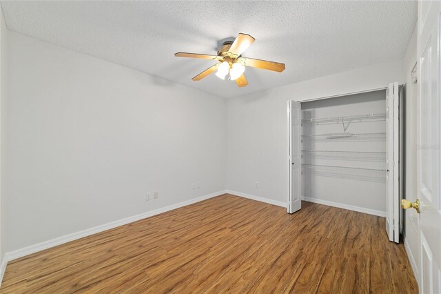 9117 SW 93rd Cir, Ocala, FL 34481 - unfurnished bedroom with wood finished floors, a textured ceiling, a closet, and ceiling fan