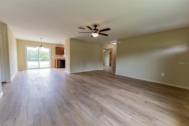 21 Locust Loop Radl, Ocala, FL 34472 - unfurnished living room featuring a ceiling fan, light wood-style floors, and a chandelier