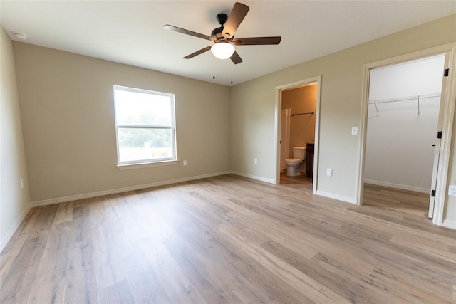 21 Locust Loop Radl, Ocala, FL 34472 - unfurnished bedroom with light wood-type flooring, a spacious closet, ensuite bathroom, a closet, and a ceiling fan
