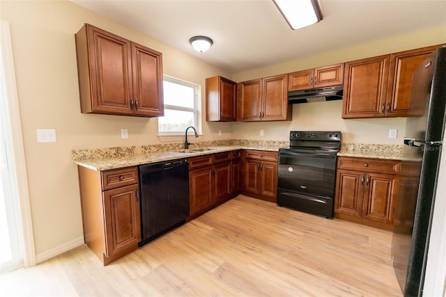 21 Locust Loop Radl, Ocala, FL 34472 - kitchen featuring black appliances, extractor fan, light wood finished floors, and light stone counters