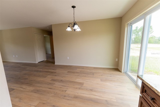 21 Locust Loop Radl, Ocala, FL 34472 - empty room with healthy amount of natural light, a chandelier, and light wood-style flooring