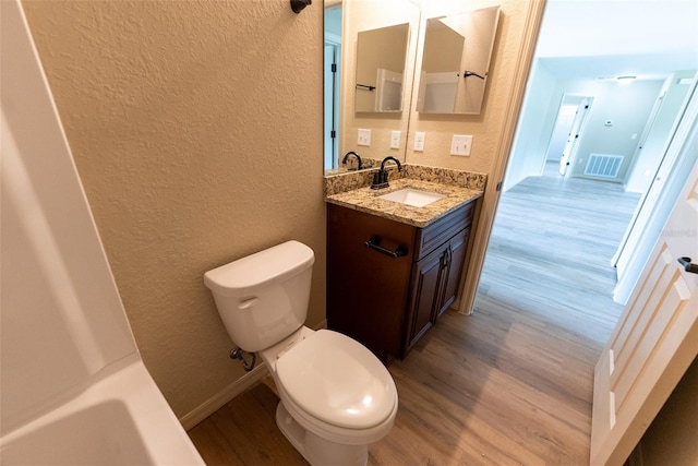 21 Locust Loop Radl, Ocala, FL 34472 - full bath featuring a textured wall, wood finished floors, vanity, and a tub to relax in