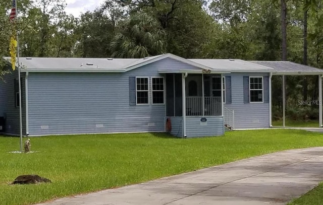 10991 SE 125th Ct, Dunnellon, FL 34431 - view of front of home featuring a front yard, a sunroom, and view of wooded area